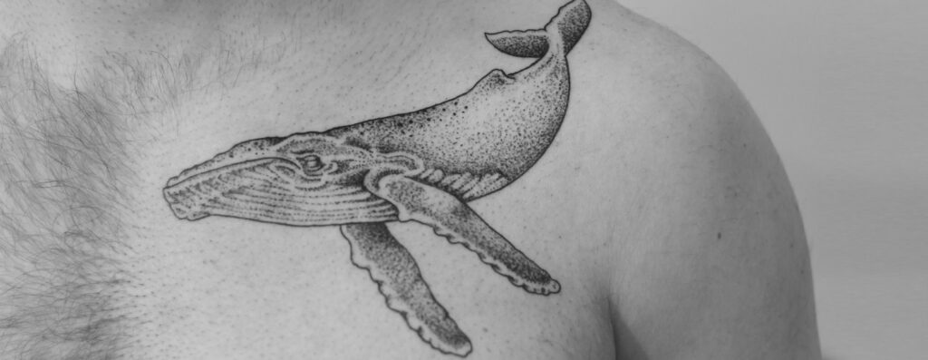 Illustratieve dotwork tattoo van een grote walvis op de borst